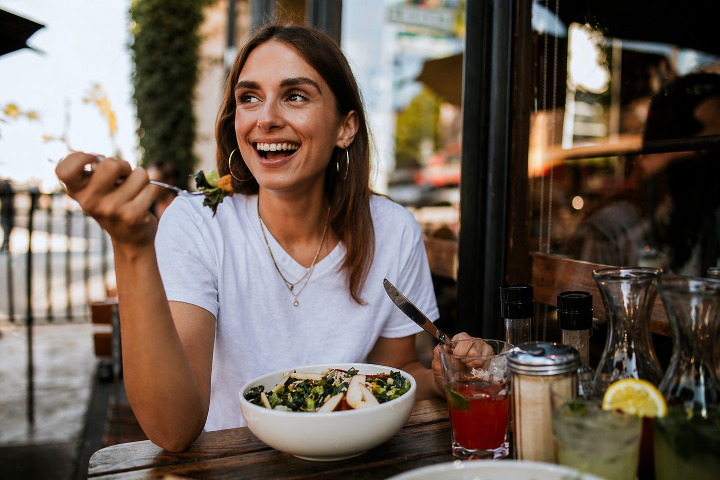 Forever Rising client smiling at a restaurant while traveling
